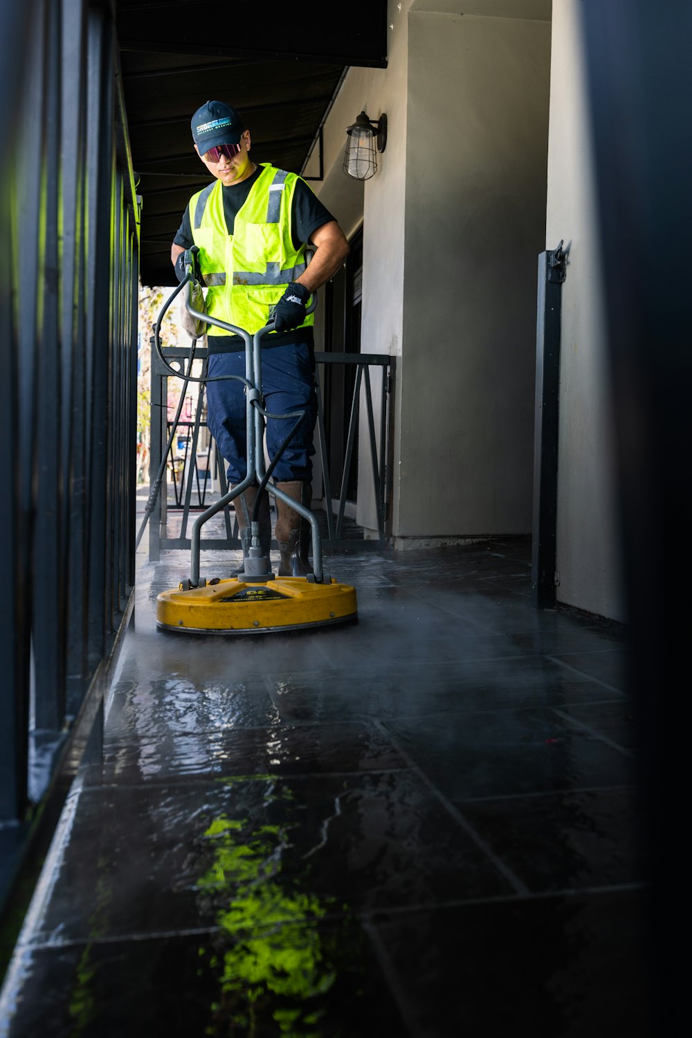 Contractor in a high-visibility vest cleaning a commercial floor