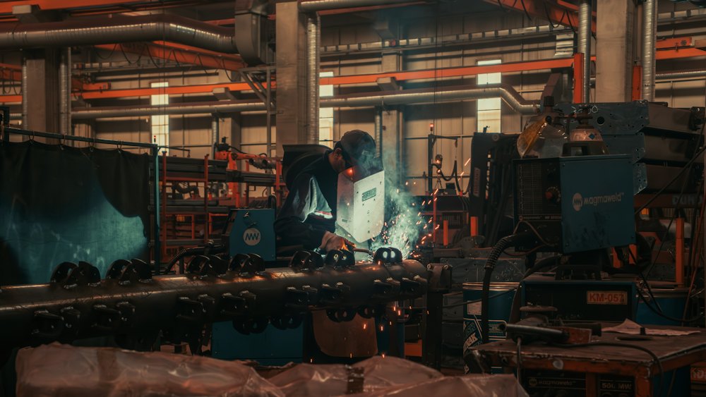 Factory floor with a worker operating heavy machinery