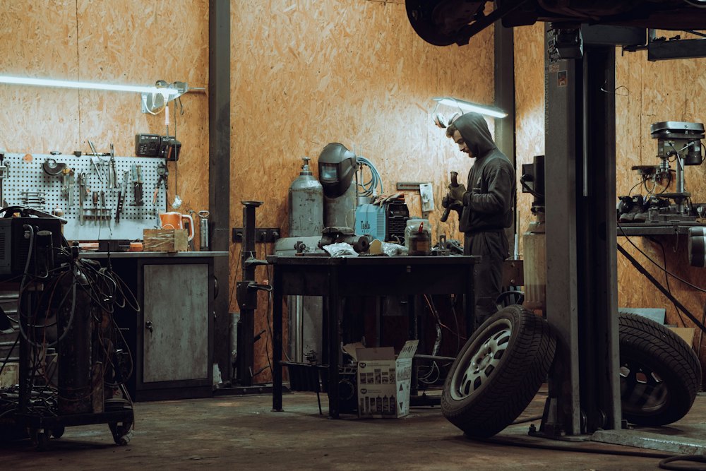 Mechanic working at a bench inside a vehicle workshop