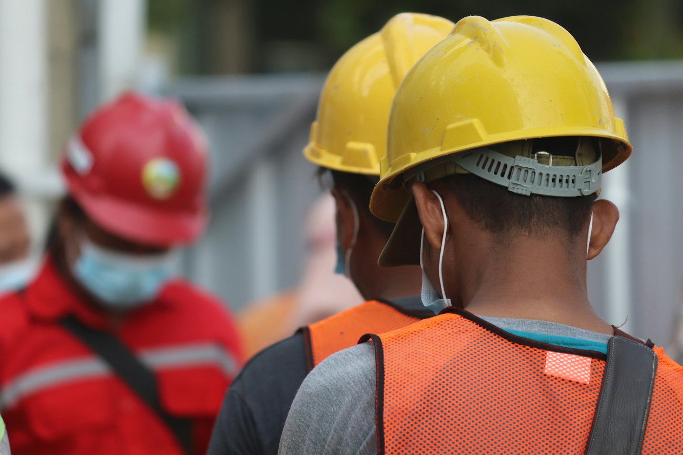 Site workers in yellow hard hats and safety vests